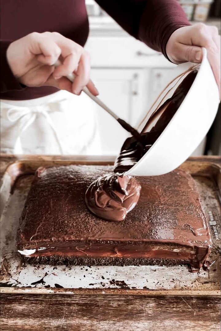Pouring chocolate ganache onto cake.