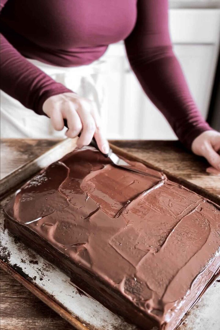 Spreading chocolate ganache over cake.