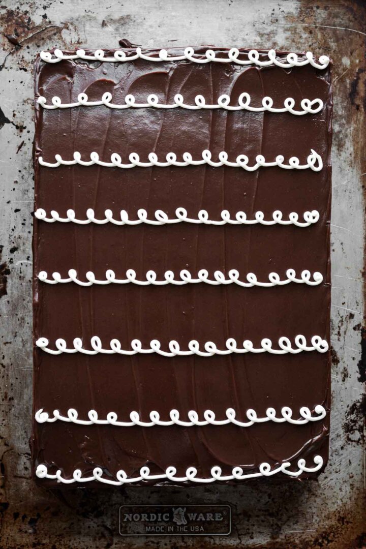 Chocolate hostess sheet cake decorated with curly icing on a baking sheet.