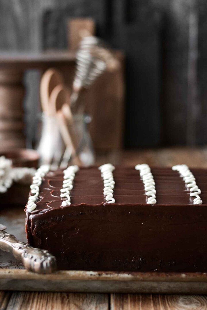 Chocolate sheet cake with curly white icing on top.
