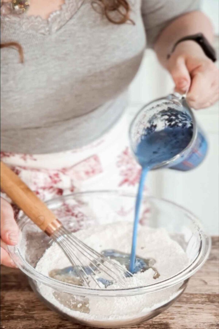 Pouring blue milk into cake batter.