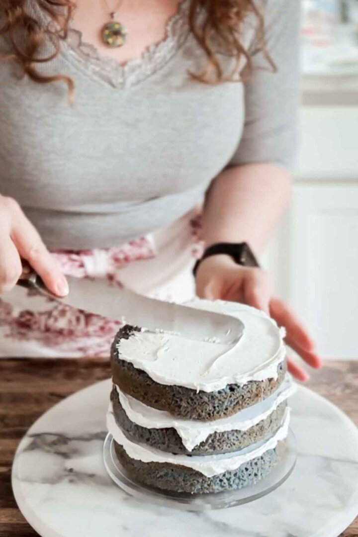 Spreading frosting onto a layer cake.
