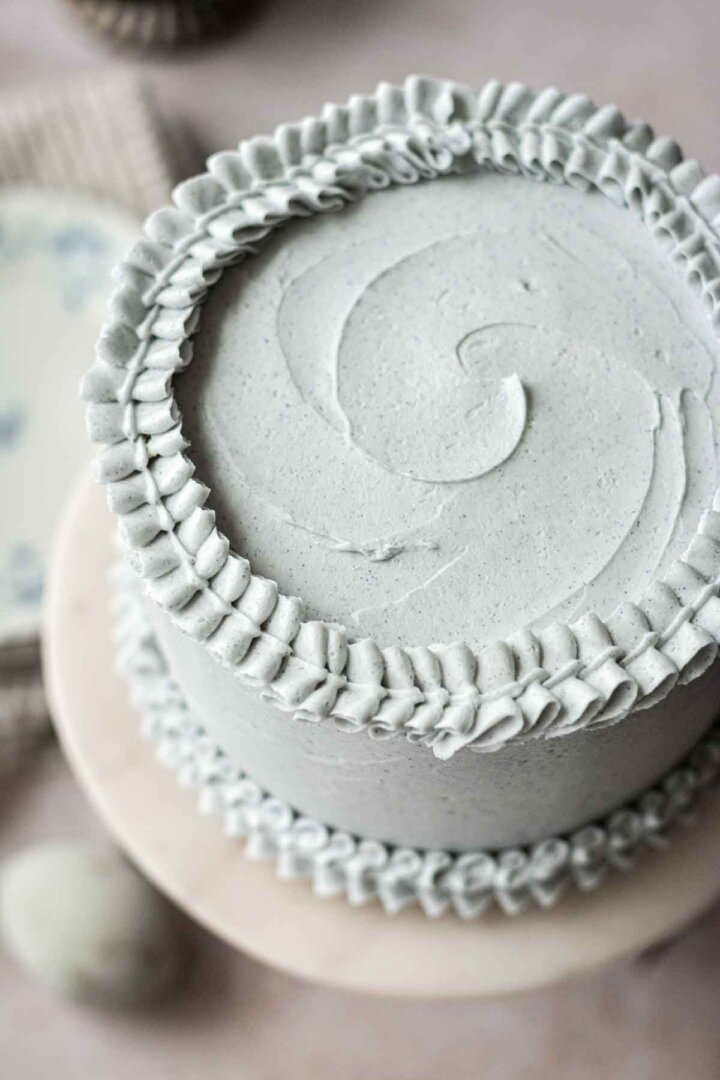 Layer cake with pale blue buttercream, piped with ruffly edges.