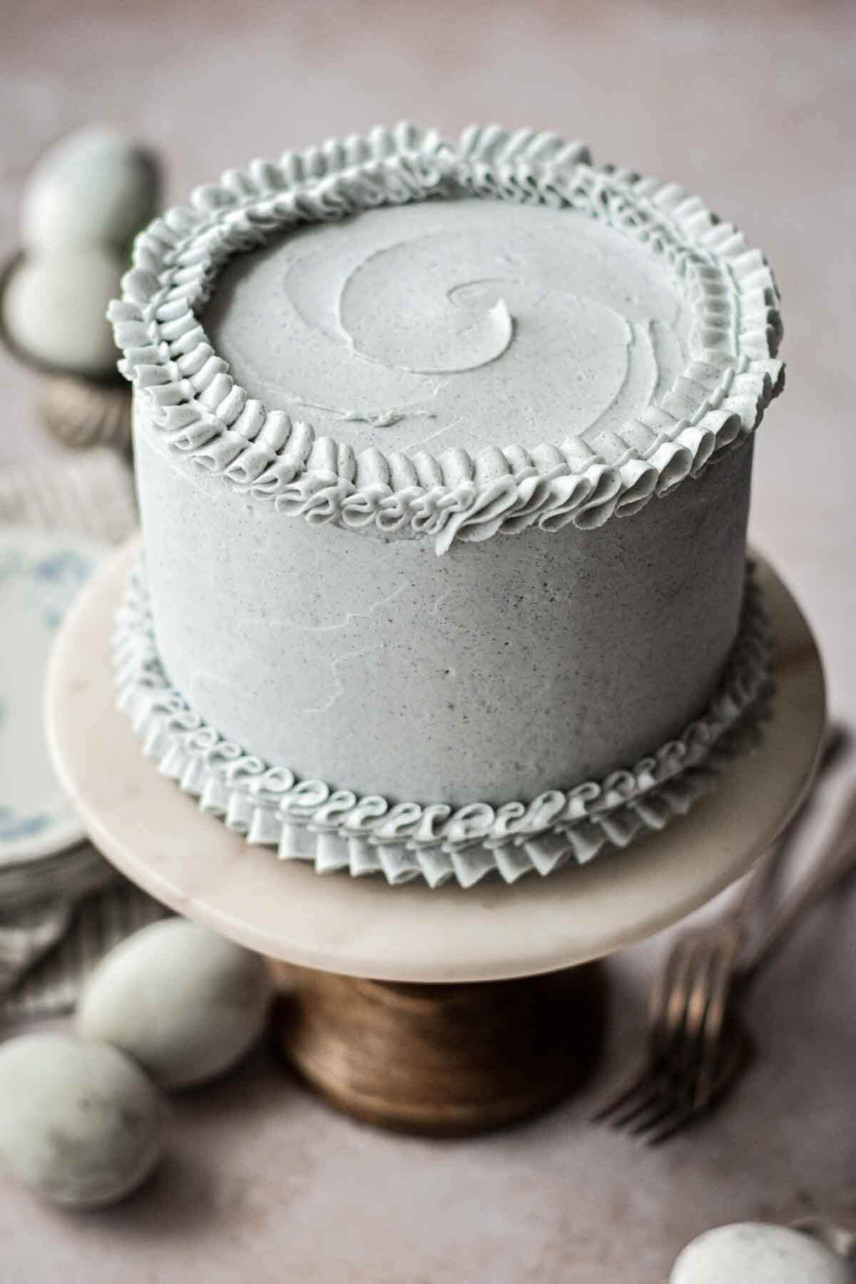 Layer cake with pale blue buttercream, piped with ruffly edges.