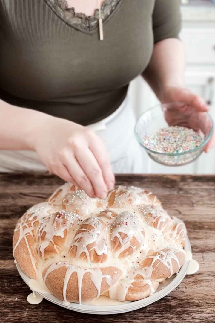 Adding sprinkles to iced bread.