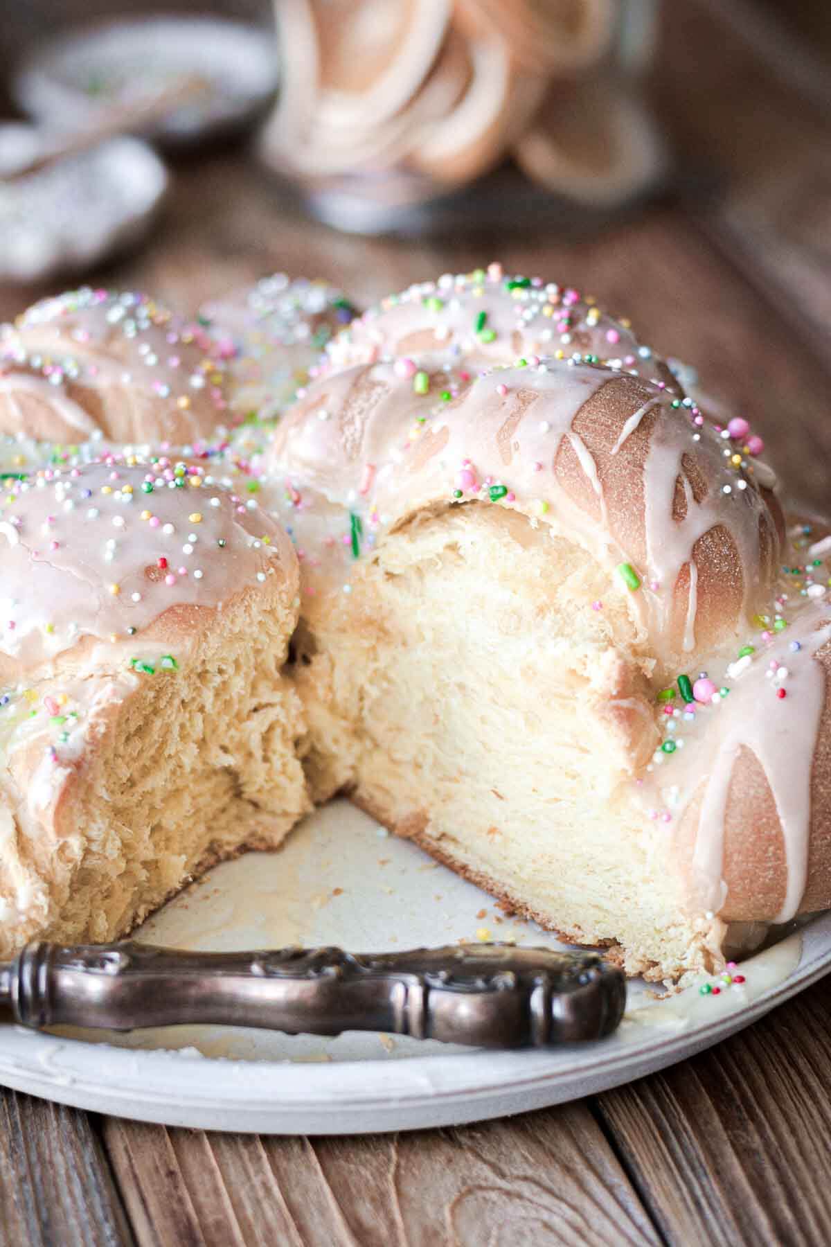 Iced bread with sprinkles with a slice cut.