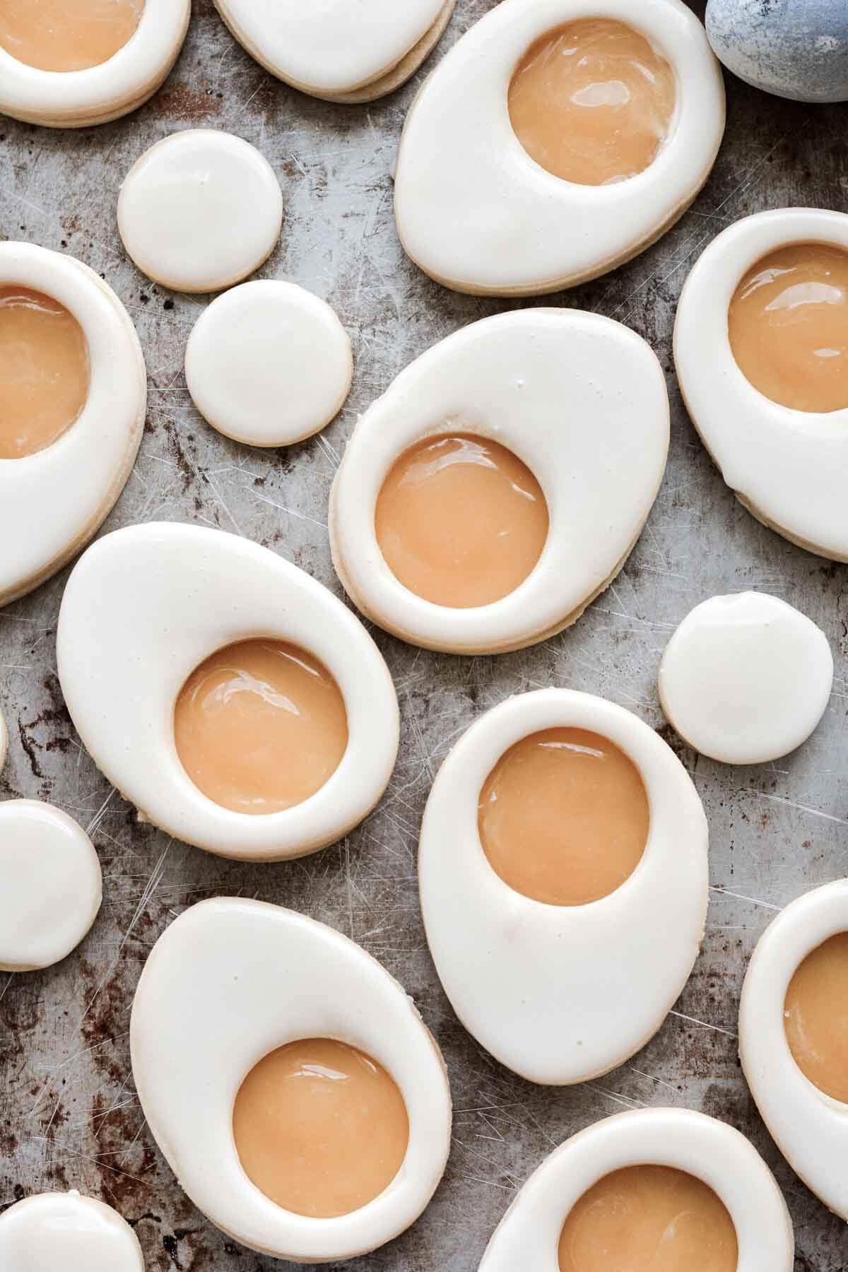Iced lemon curd linzer cookies that look like hard boiled eggs.