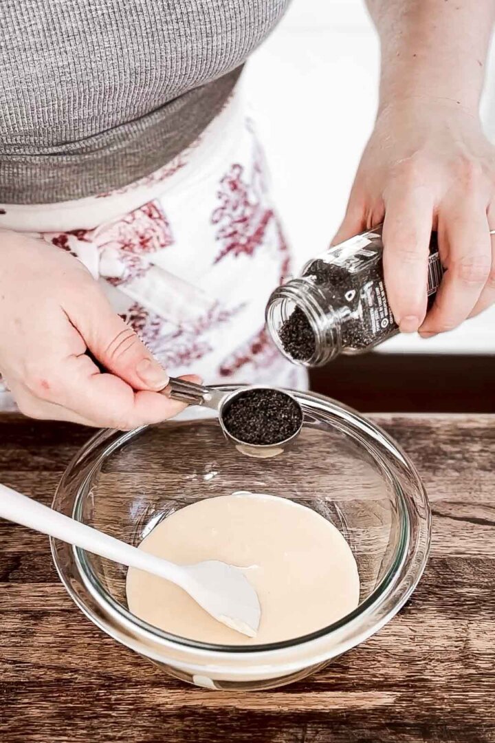 Adding poppy seeds to cake batter.