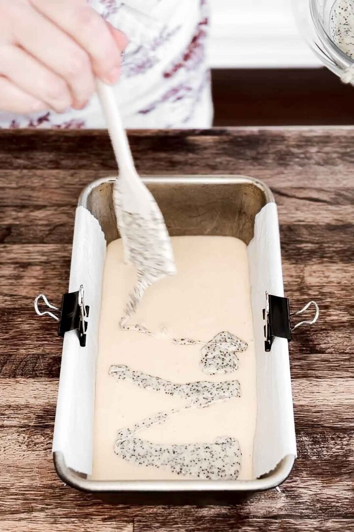 Swirling together vanilla cake batter with poppy seeds.