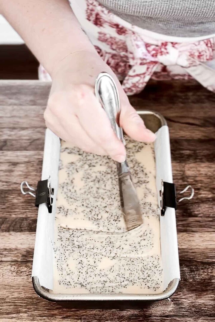 Swirling together vanilla cake batter with poppy seeds.