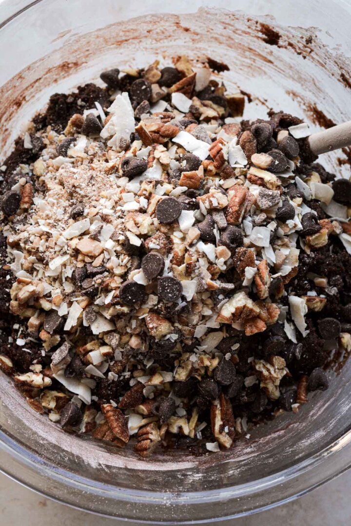 Step 6 for making German chocolate cookies: mixing coconut, chocolate chips, pecans and toffee into the dough.