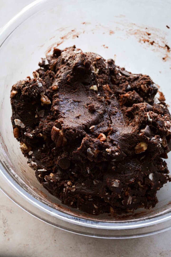 Step 7 for making German chocolate cookies: mixing coconut, chocolate chips, pecans and toffee into the dough.