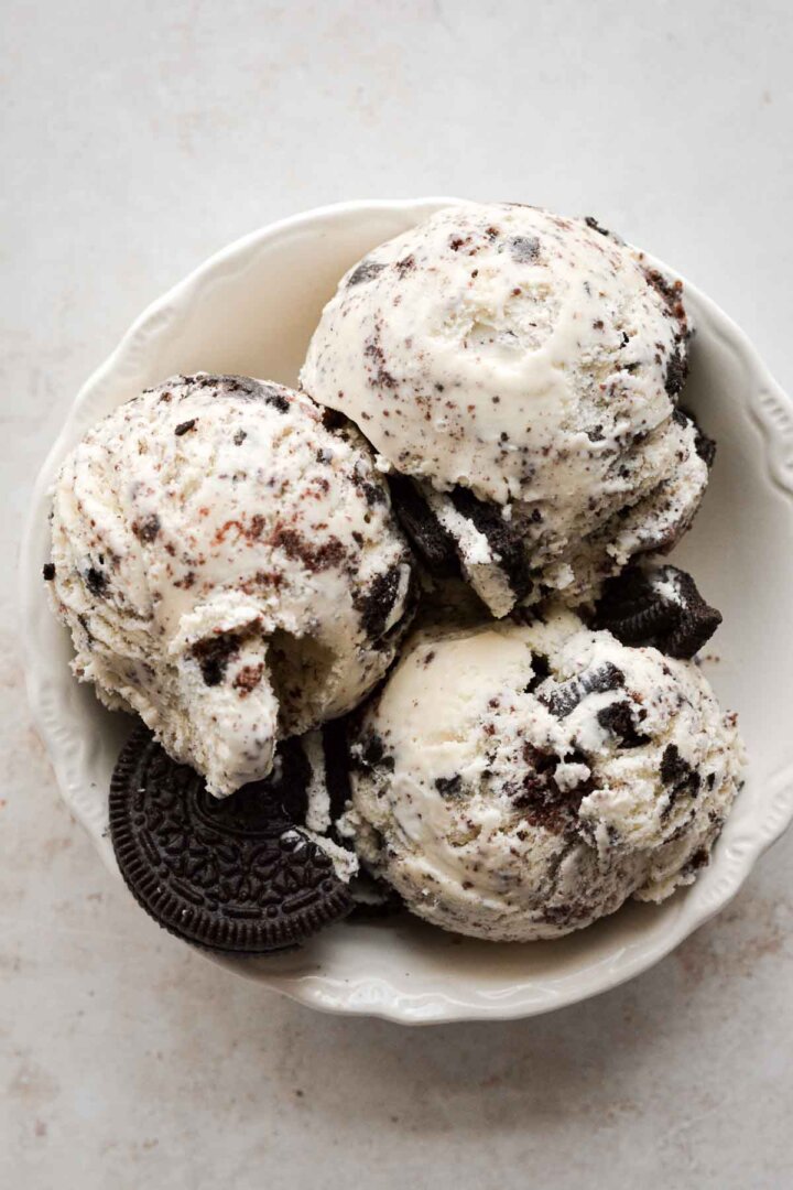 Bowl of cookies and cream ice cream with broken Oreos.