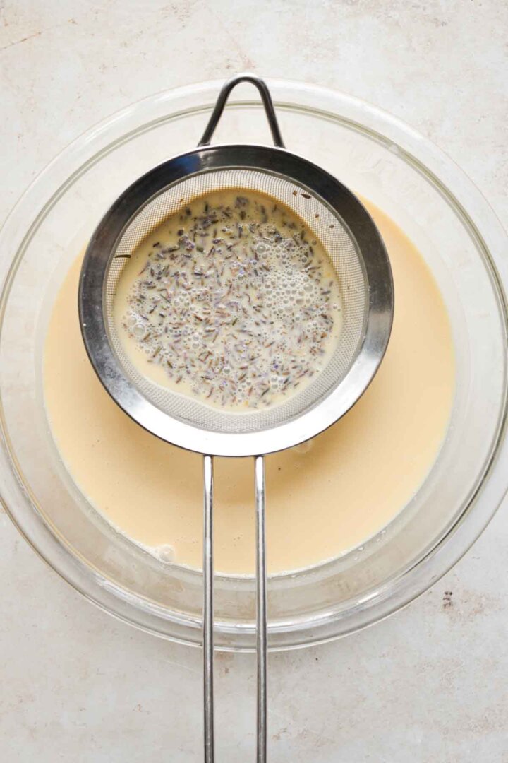 Straining lavender from a bowl of lemon custard.