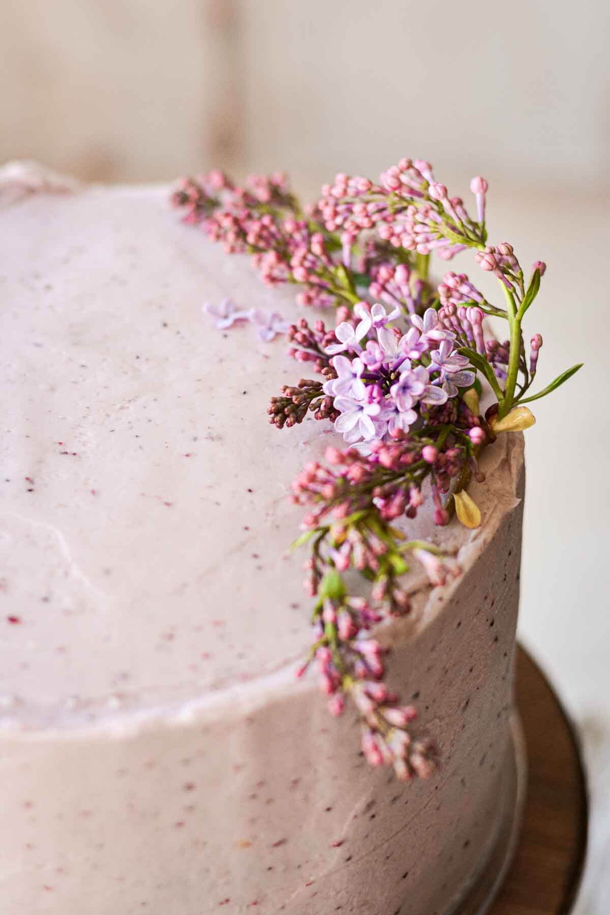 Fresh lilacs on a cake with blueberry buttercream.