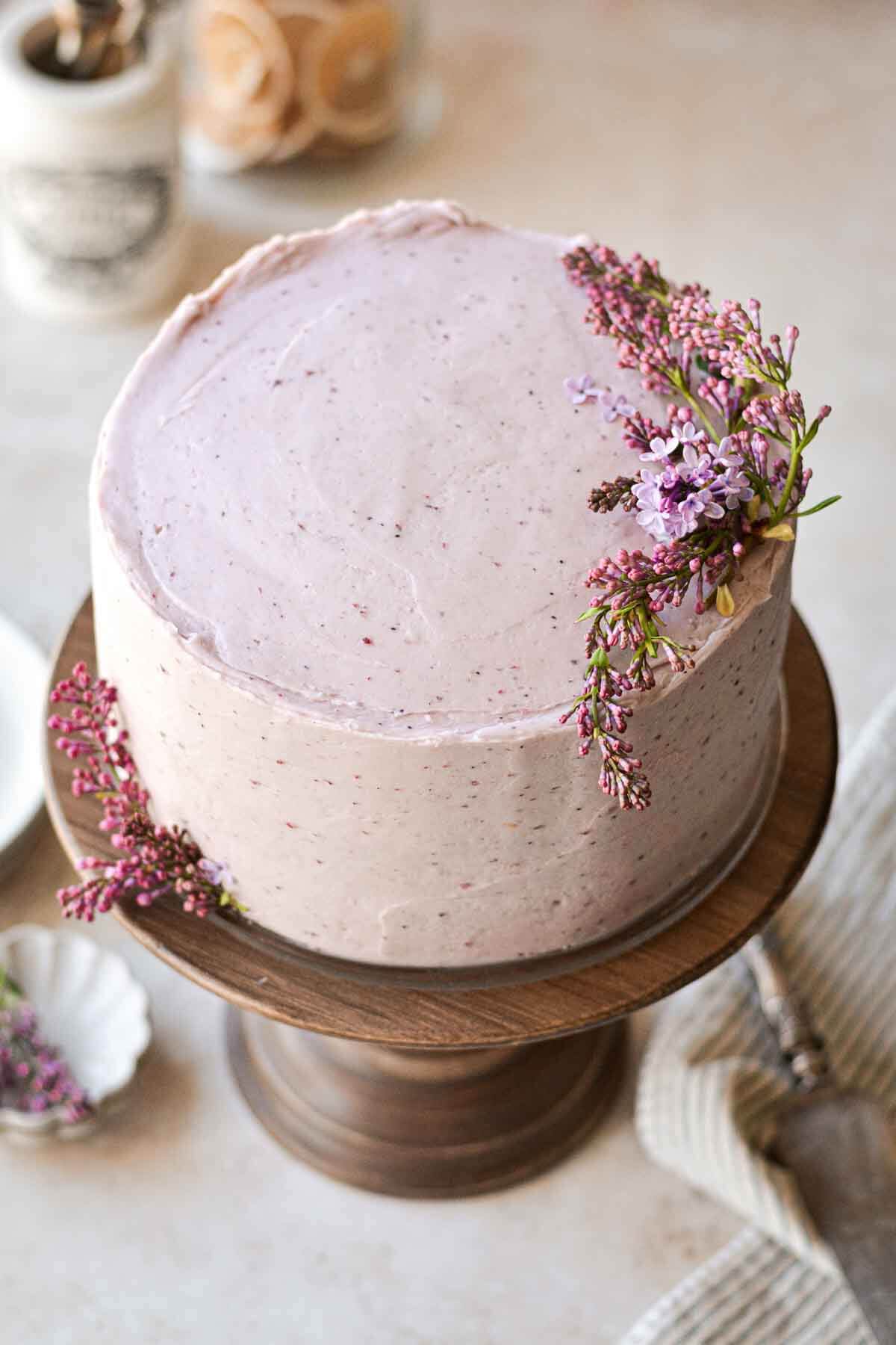 Lemon blueberry layer cake, decorated with fresh lilacs.