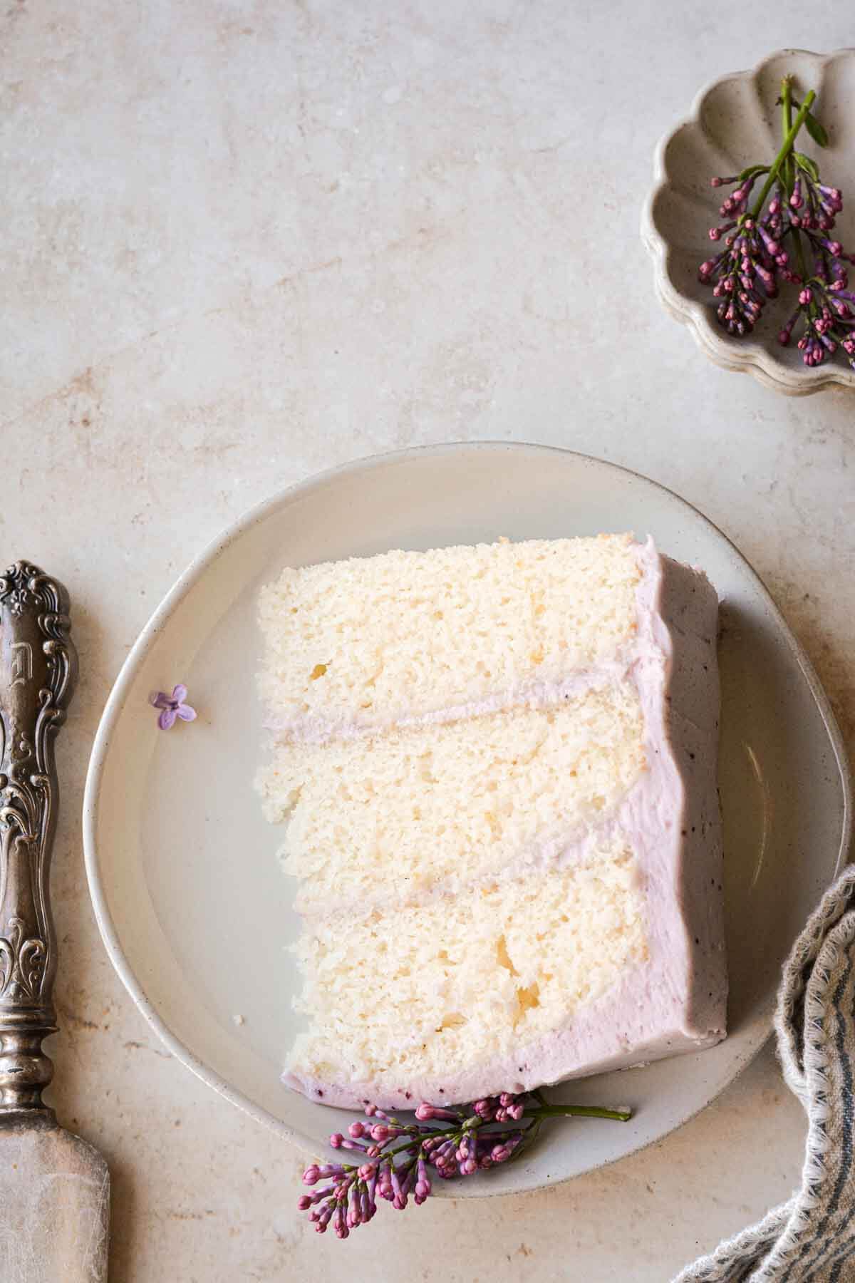 A slice of lemon blueberry layer cake on a plate.