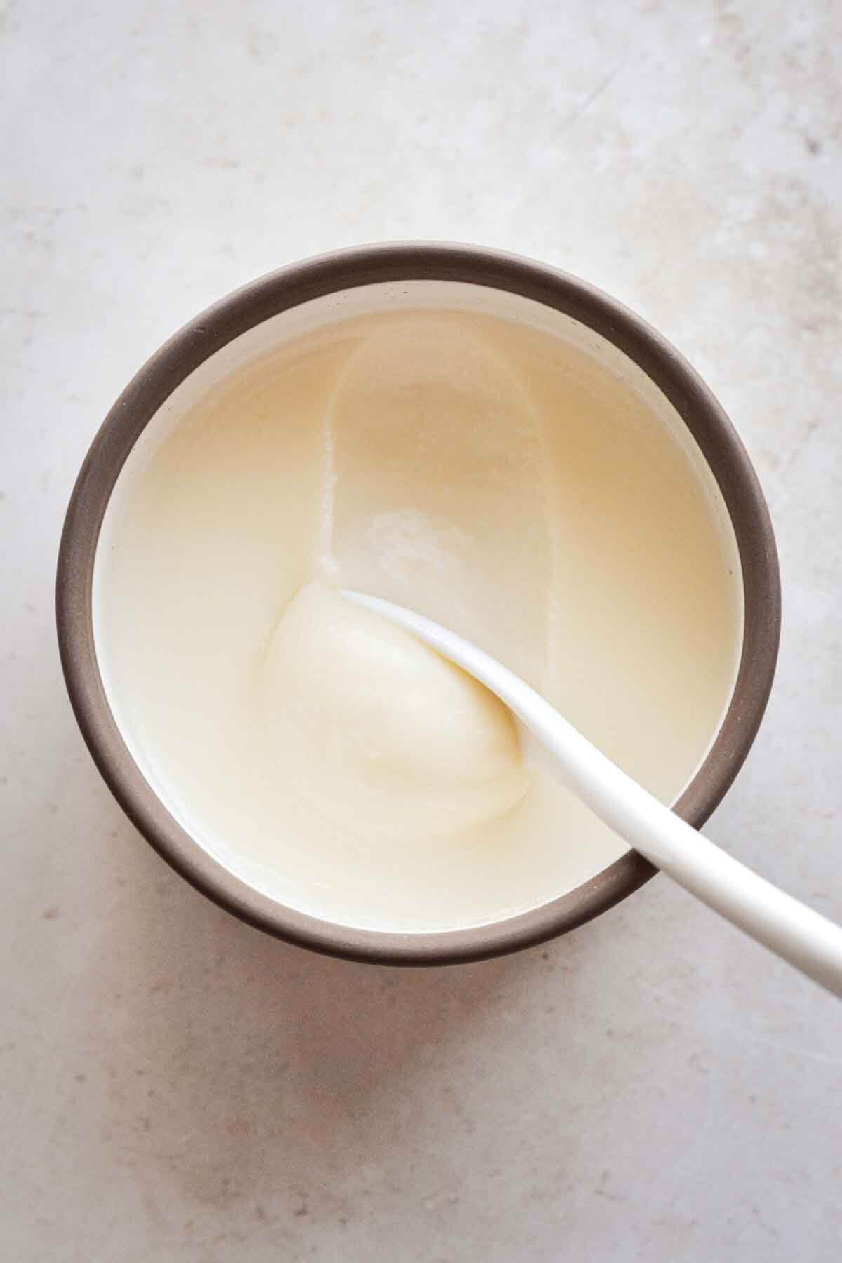 Lemon posset, with a white spoon.