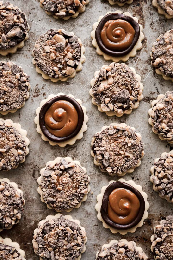 Millionaire's shortbread cookies with chocolate ganache, dulce de leche, and toffee bits.