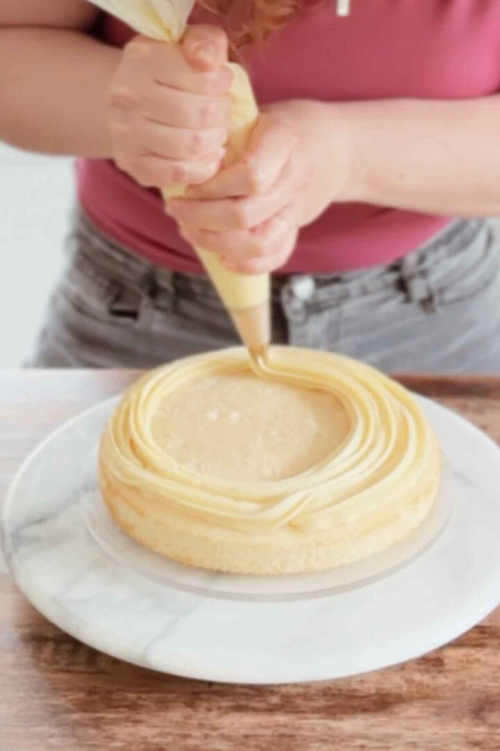 Piping custard onto a cake.
