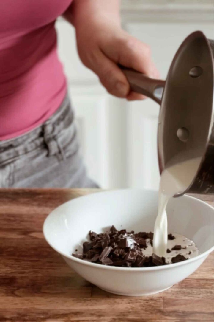 Pouring hot cream over chopped chocolate.