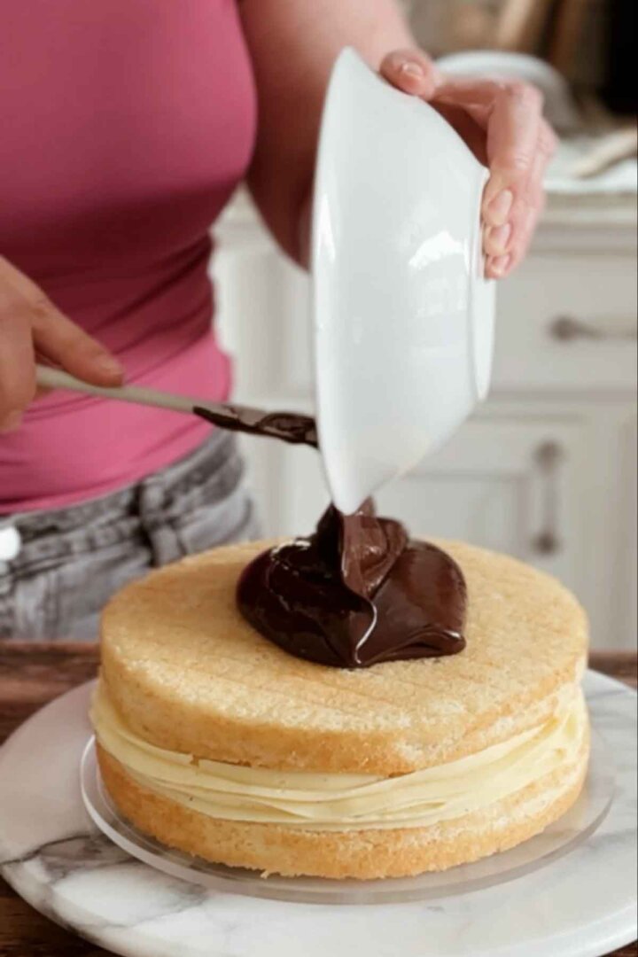 Pouring ganache onto a cake.