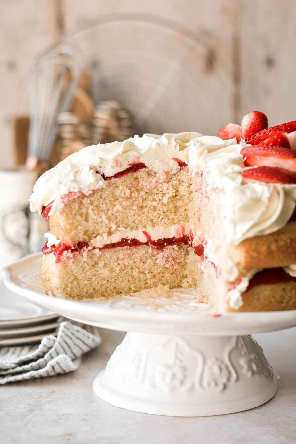 Strawberry chamomile cake with a slice cut.