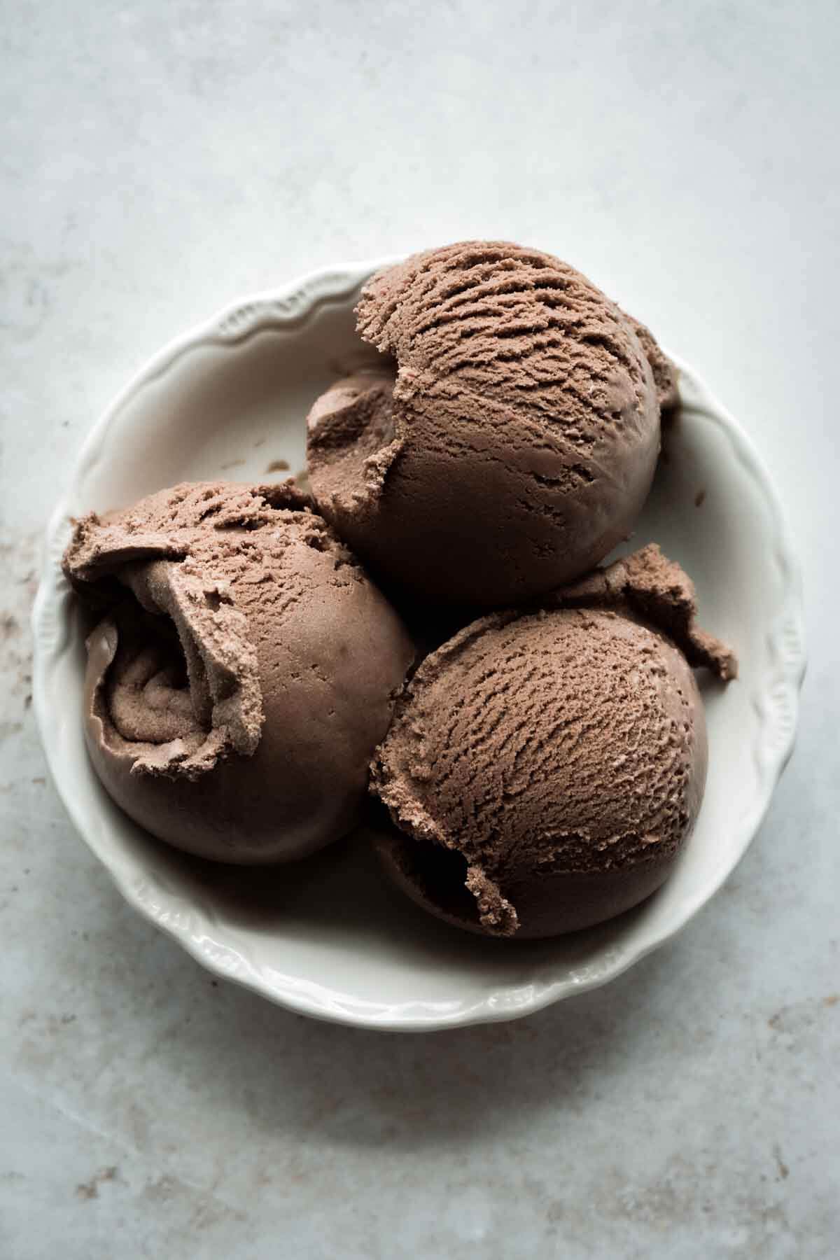 Scoops of chocolate ice cream in a bowl.