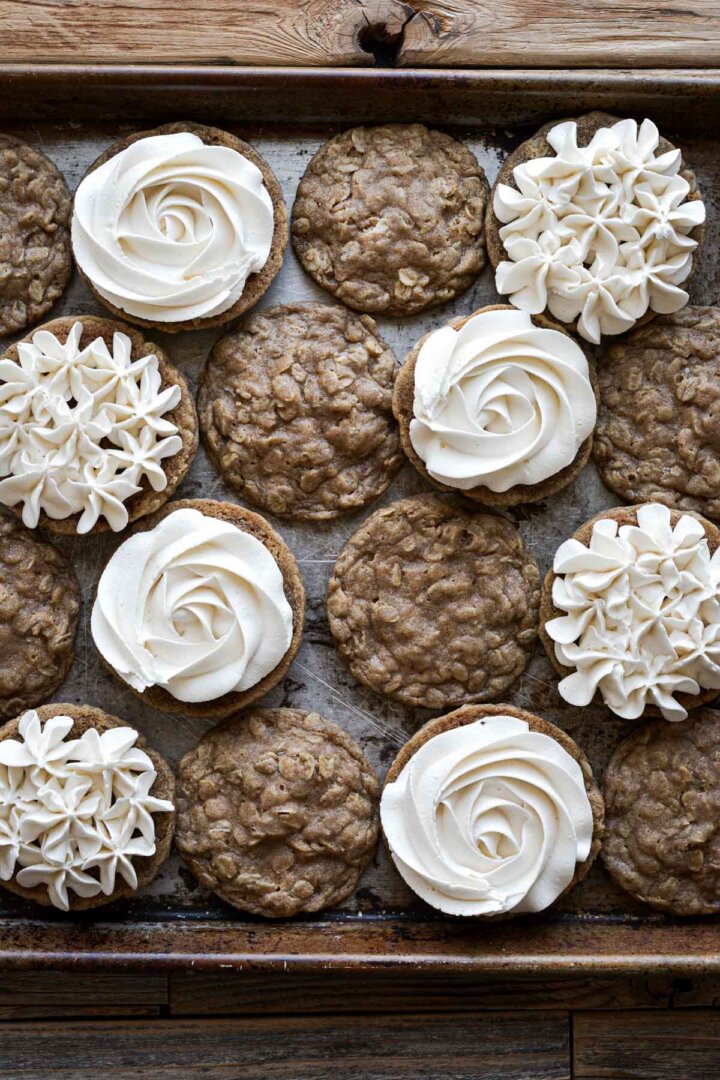 Oatmeal cookies, half with buttercream piped onto the cookies.