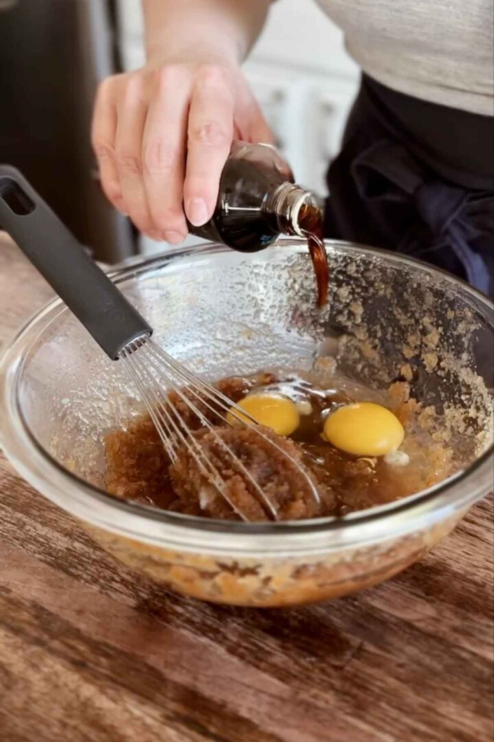 Step 2 for making oatmeal cookies - whisking in eggs and vanilla.