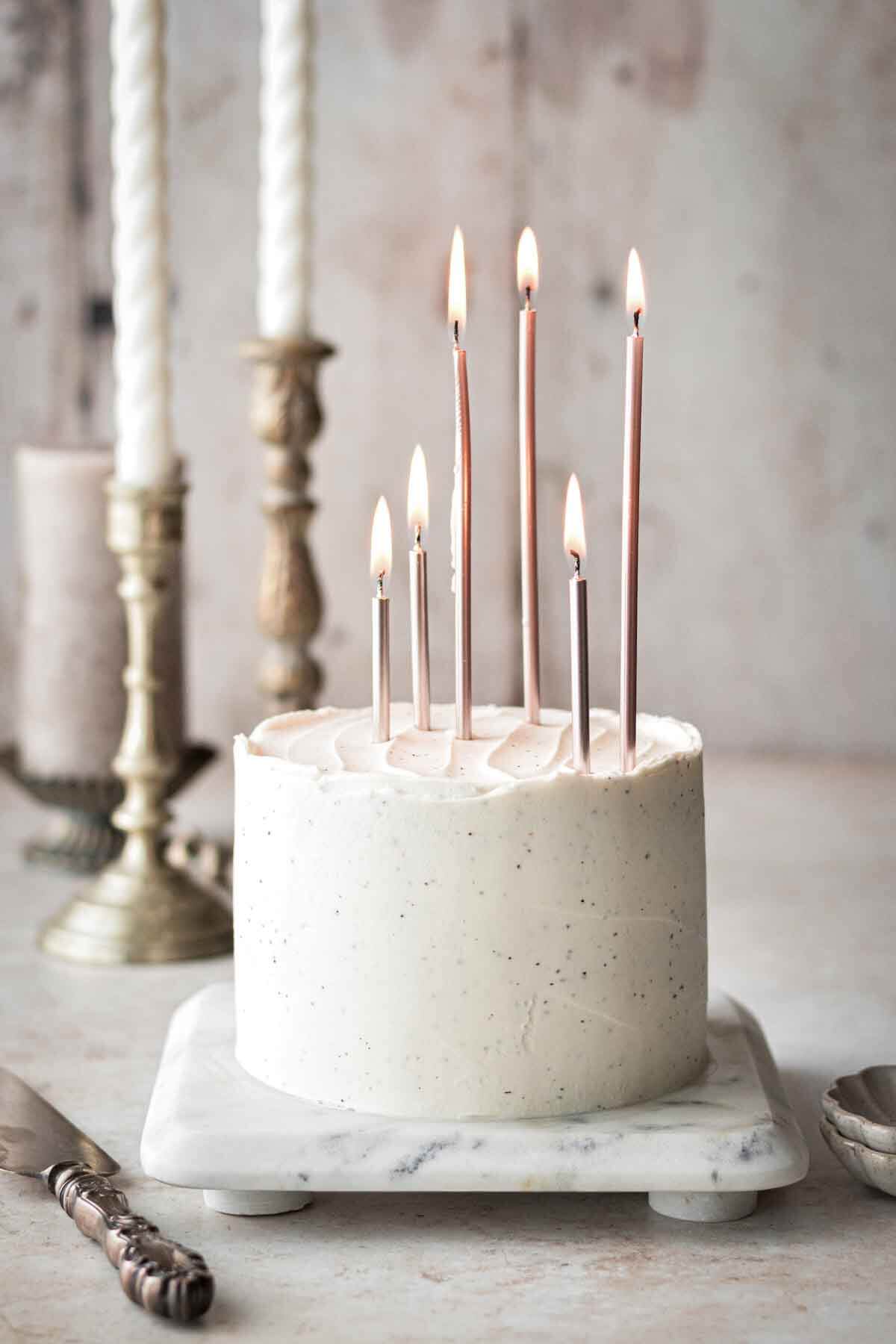 White velvet cake with tall pink birthday candles.