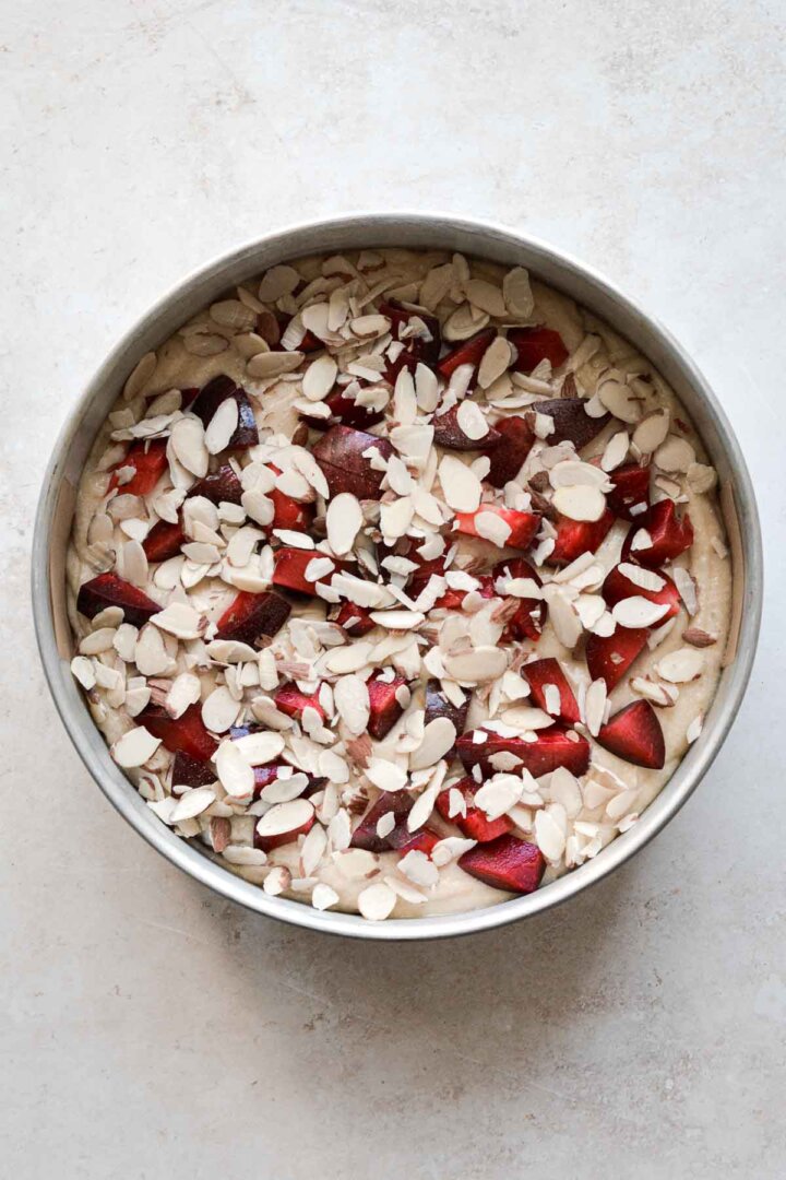 Step 3 for making almond plum cake - almonds sprinkled over cake.