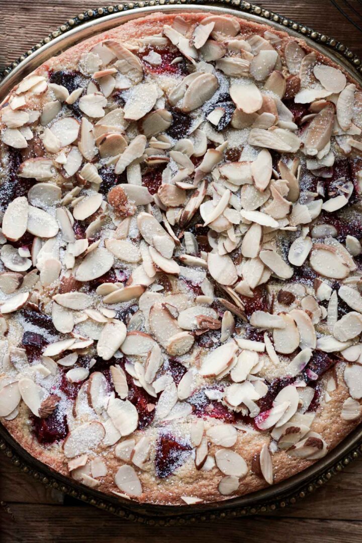 Almond plum cake topped with sliced almonds.