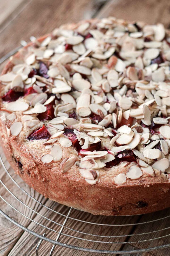 Almond plum cake on a cooling rack.