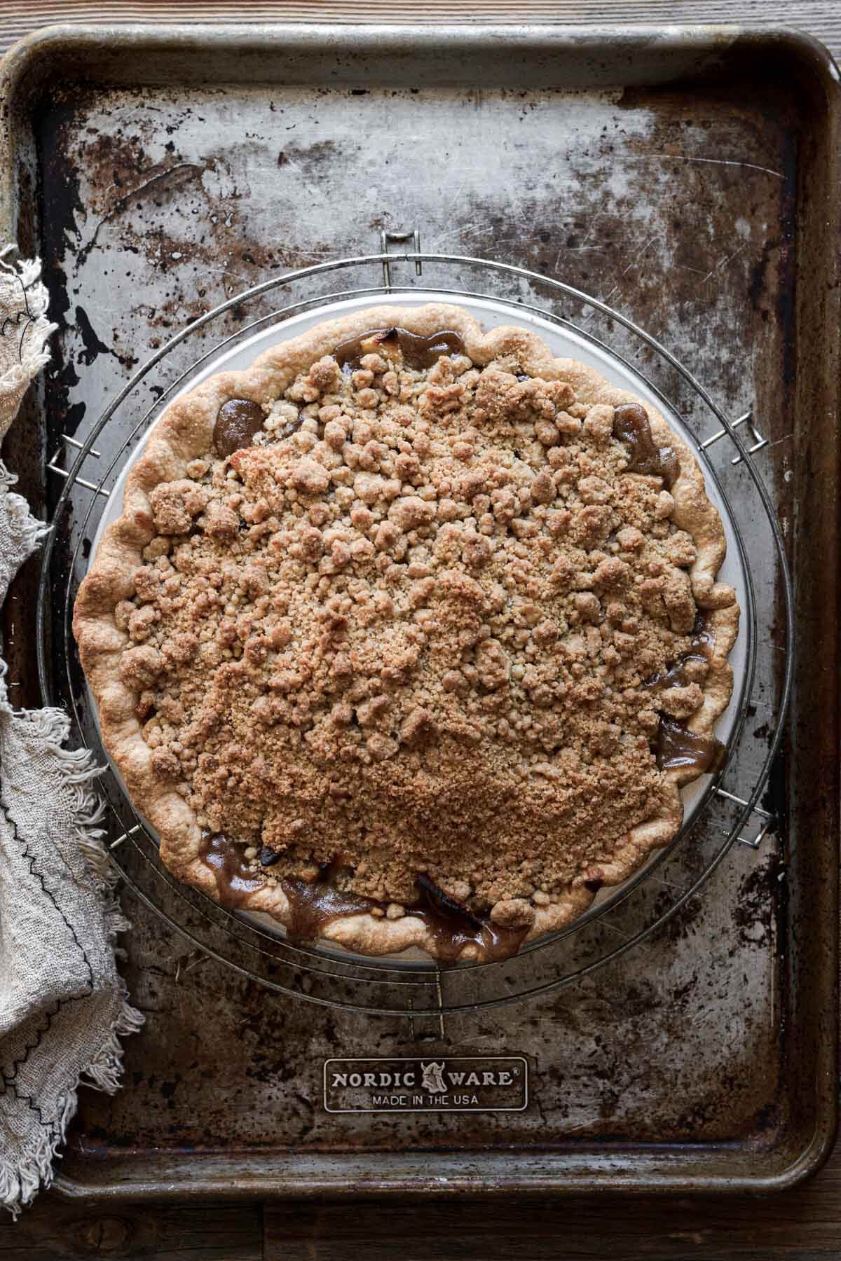 Apple crumb pie, cooling on a baking sheet.