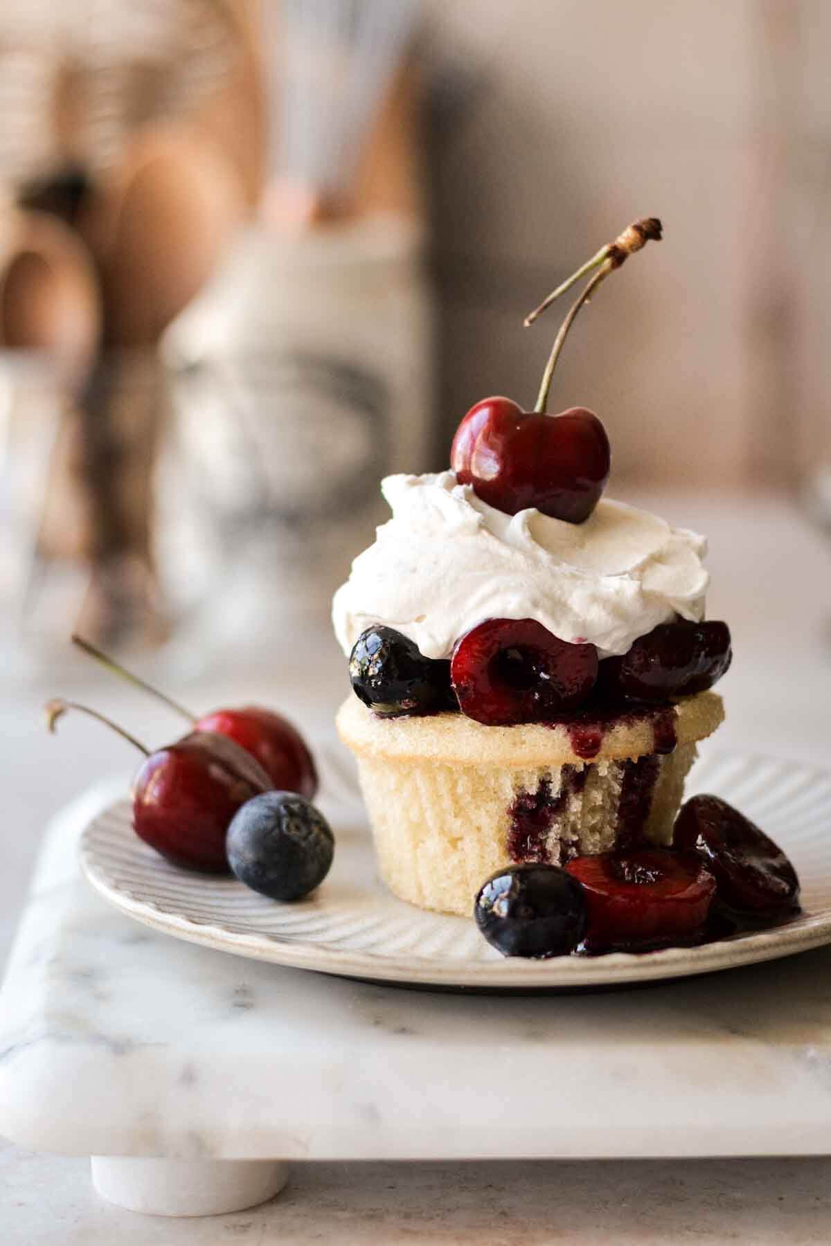 Cherry blueberry shortcake - a vanilla cupcake with berry compote and whipped cream.