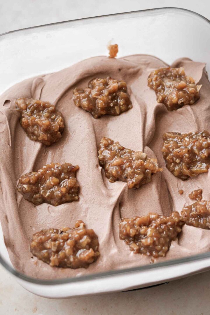 Coconut caramel frosting dolloped over chocolate ice cream.