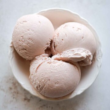Scoops of rhubarb ice cream in a bowl.