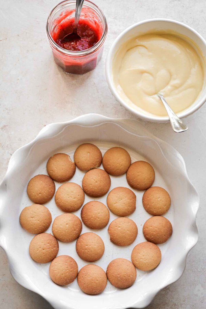 Step 1 for making strawberry pudding - cookies layered in a pie pan.