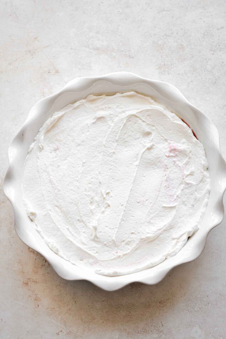 Step 4 for making strawberry pudding - whipped cream layer.