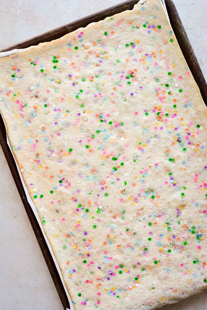 Sprinkle cake baked in a rimmed baking sheet.