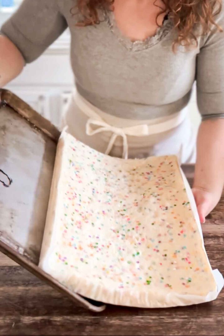 Step 1 for assembling a table runner cake - sliding the cake off the baking sheet.