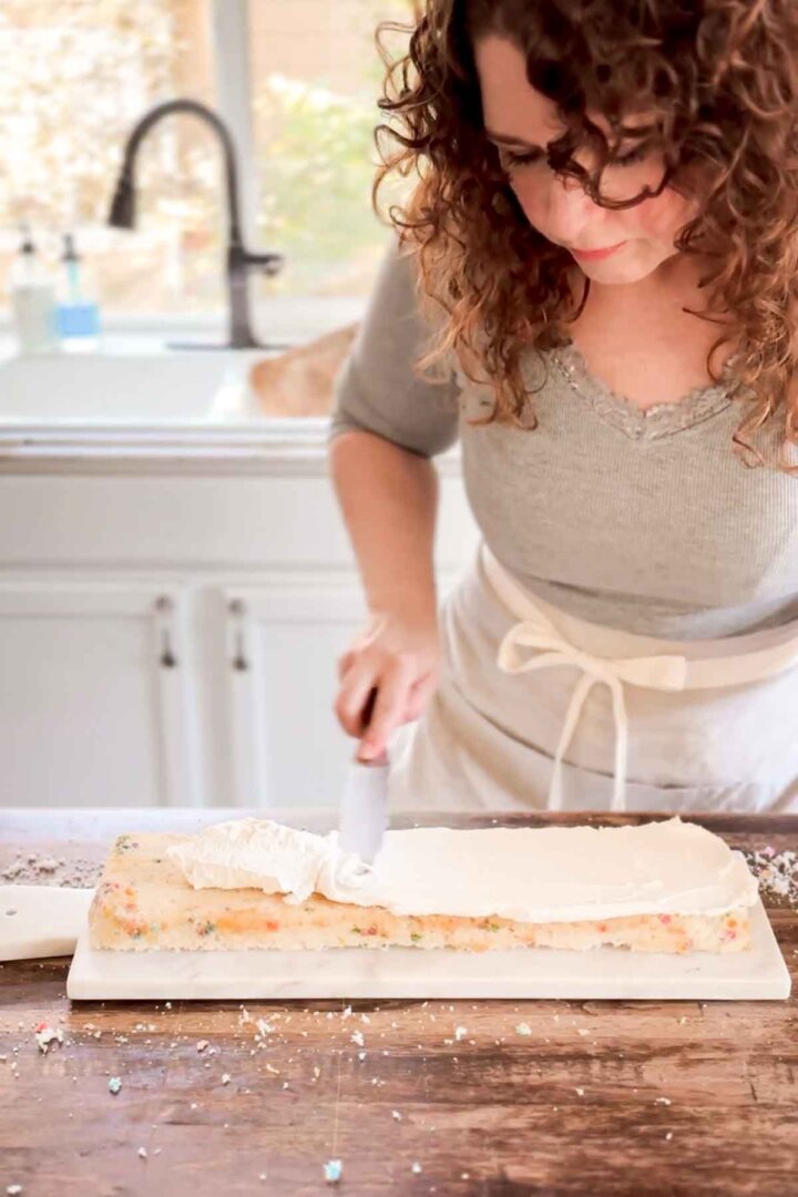 Step 4 for assembling a table runner cake - frosting the first cake layer.
