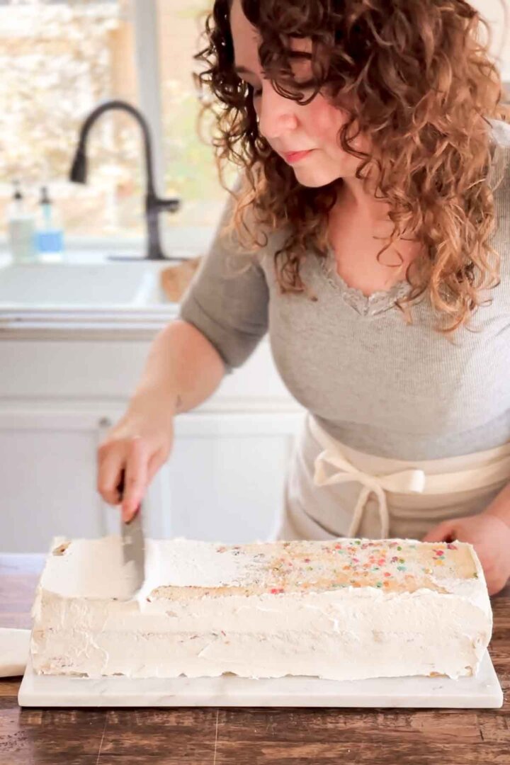 Step 5 for assembling a table runner cake - frosting the cake with a crumb coat of buttercream.