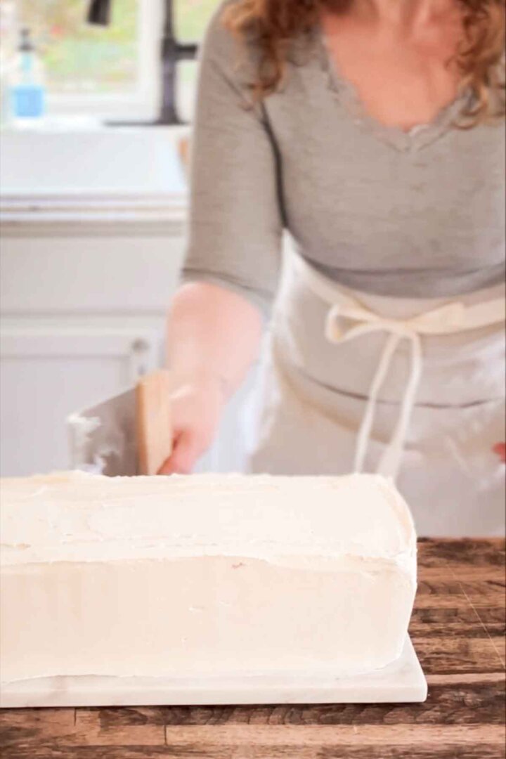 Step 6 for assembling a table runner cake - smoothing the buttercream.