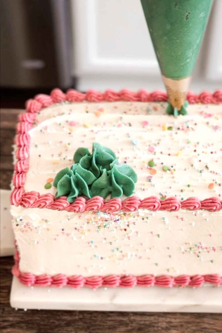 Step 8 for assembling a table runner cake - piping green flowers.