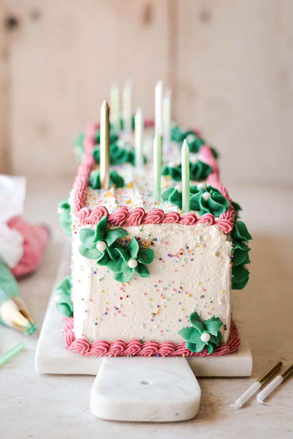 Table runner cake topped with birthday candles.