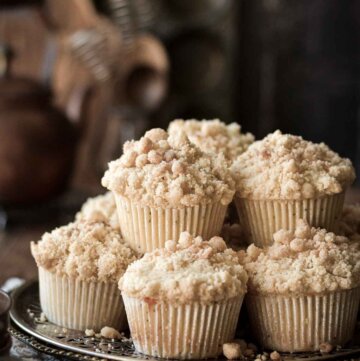 Almond poppy seed muffins stacked on a plate.