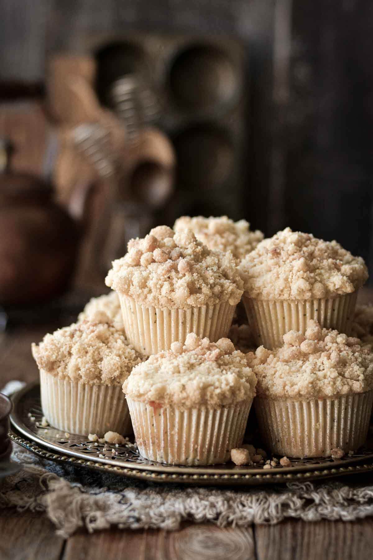 Almond poppy seed muffins stacked on a plate.
