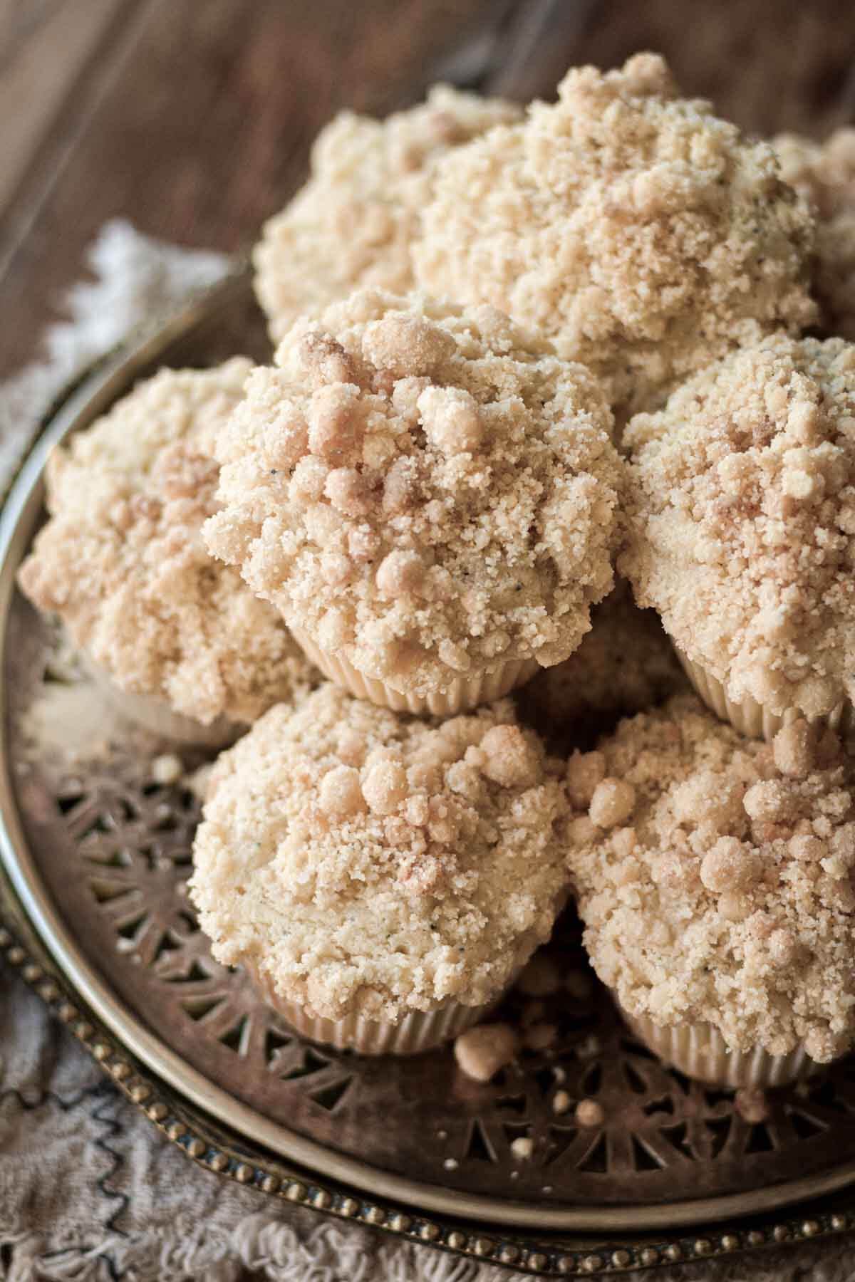 Almond poppy seed muffins stacked on a plate.